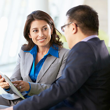 A business woman and business man looking at an iPad